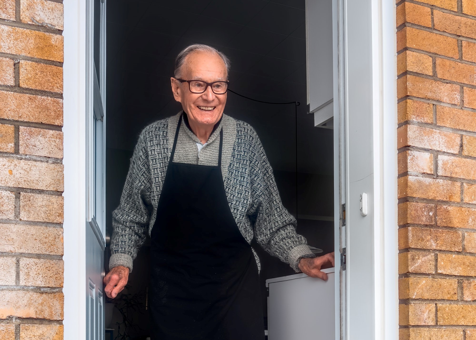 Old man with eyeglass and afron smiling