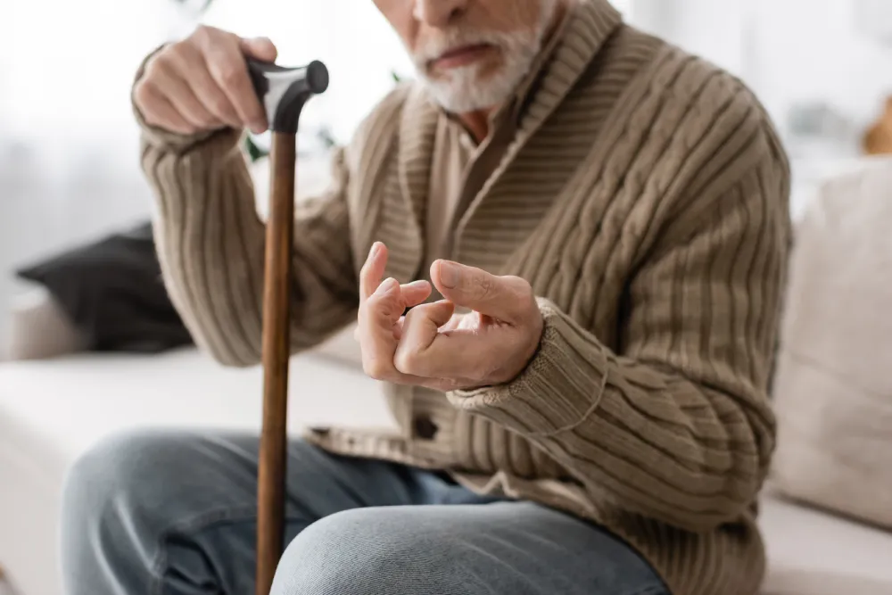 Caregiver assisting senior woman with walking at home hallway with support